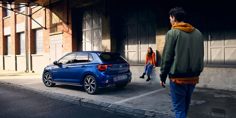 Zwei Personen und ein geparkter VW Polo