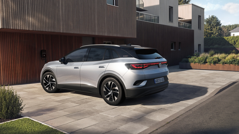 Silberner VW ID.4 ENERGY vor modernem Haus mit Holzfassade